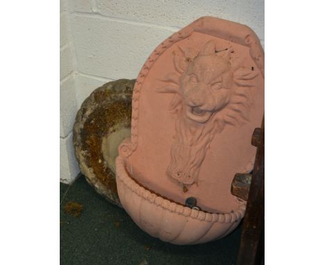 A terracotta wall mounted lion mask water spout and trough approx 75cm high together with a circular stone effect bird bath (