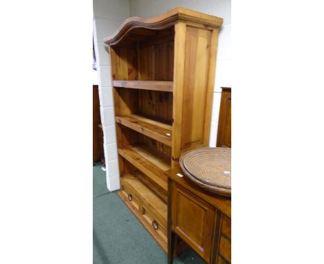 A modern waxed pine, open four shelf bookcase, fitted two narrow drawers to the base, arched top and planked back.  108cm len