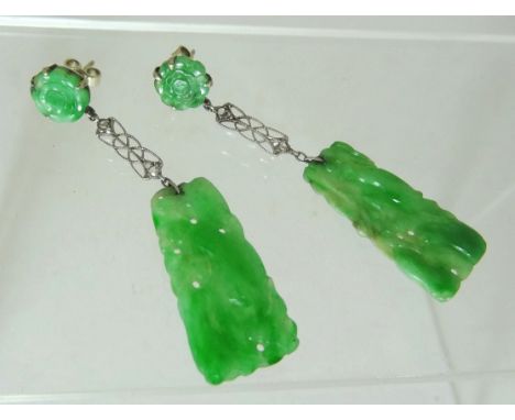 A pair of Jade panel drop pierced earrings.  The carved green jade panels supported on filigree white metalwork, set with fou
