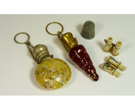 A small late 19th Century red glass scent bottle with hinged gilt cover and ring suspension, 6.5cms long; a mottled yellow gl