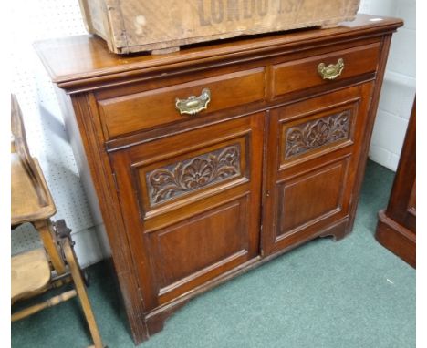 A Victorian mahogany side cabinet, fitted two narrow drawers above a pair of panelled doors with carved decoration, enclosing