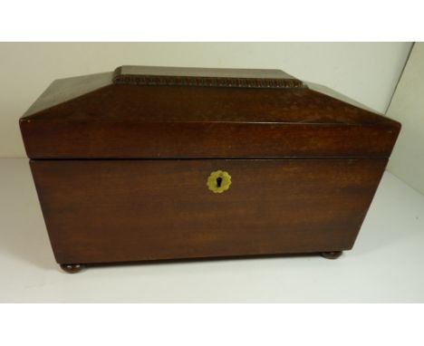A 19th Century mahogany sarcophagus shaped tea caddy fitted with two lidded compartments and central compartment for bowl, on