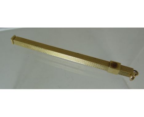 A 9ct gold, Art Deco Style Swizzle Stick, of square form with engine turned decoration. 6.5g approx.
