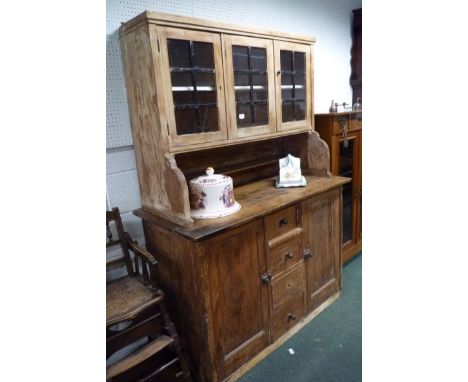 A Victorian pine kitchen dresser (marriage).  The base fitted four central drawers, cupboard to either side, the panelled bac