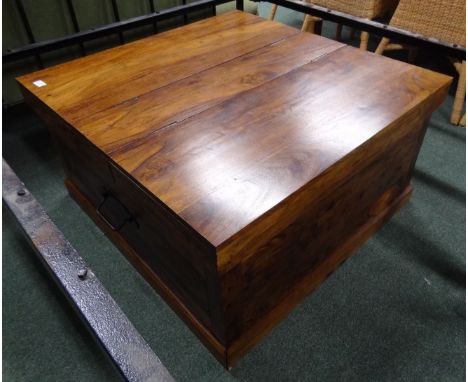 A modern square coffee table/trunk, pair of hinged lids opening to reveal storage, metal side carrying handles.  86 cm square