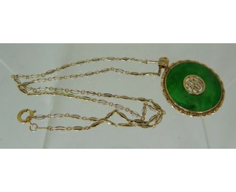 A circular green jade pendant inset gold Asian characters to centre, marked 14k and on a fine link chain, also marked 14k.