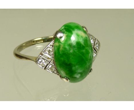 A ladies 18ct white gold and platinum set Art Deco jade and diamond ring.  The ring set with a green jade cabouchen, the shou