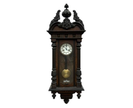 A Vienna style walnut cased wall clock, the white enamel dial with Roman numerals. 114cm high