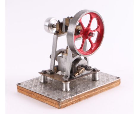 A scratch built single cylinder vertical engine with 7.5cms flywheel and steam valve coupling, 14cms high, mounted on a plint