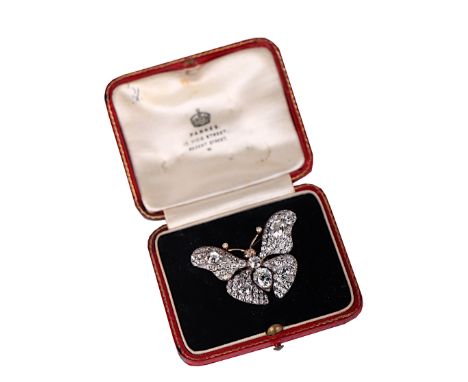 A diamond butterfly brooch with ruby eyes set in white and yellow metal, all old cut diamonds, the principal pear shaped diam