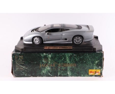 A Maisto 1:12 scale Jaguar XJ220 diecast model mounted on a plinth, boxed.