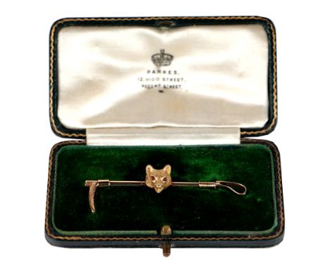 Hunting interest.  A 15ct gold fox mask and riding crop bar brooch, the fox mask set with ruby cabochon eyes, in original Par
