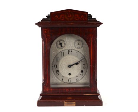 An Edwardian mantle clock, the silvered dial with Arabic numerals and German movement, in an inlaid mahogany case, 28cms wide