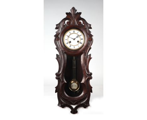 A Victorian carved walnut wall clock, the white enamelled dial with Roman numerals, fitted with a 8-day movement, 72cms high.