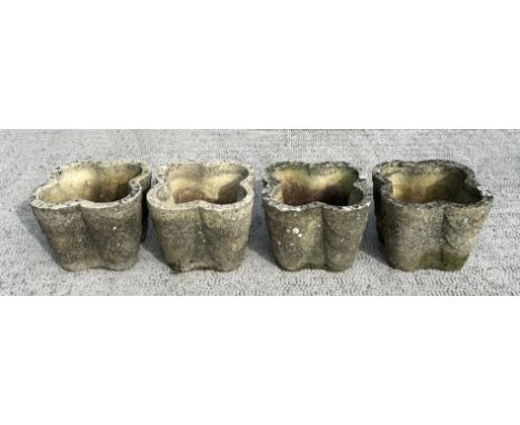 A set of four well weathered reconstituted stone lobed form planters, 32cms wide; together with a terracotta planter, 32cms d