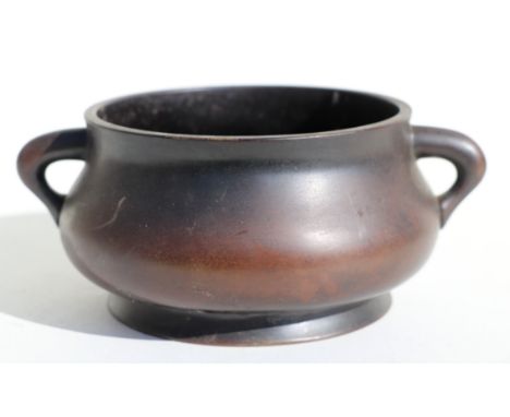 A Chinese two-handled bronze censer with six character mark to the underside, 16cms diameter.