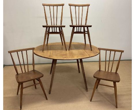 ERCOL; a beechwood and elm drop-leaf table opening to 126cm x 111cm, with four stick back chairs with green Ercol labels, mar