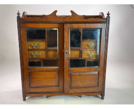 A Victorian oak smoker's cabinet with double glass doors and seven drawers and shelves to interior, wall mounted or table top