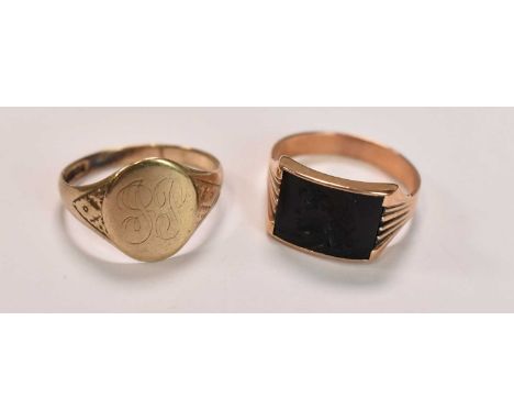 A 9ct yellow gold signet ring with traces of engraved initials, size U, and a yellow metal ring with carved central plaque, s