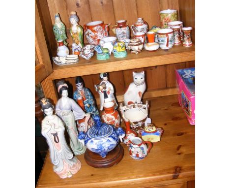 An array of oriental ceramic ware and porcelain figurines - on two levels 
