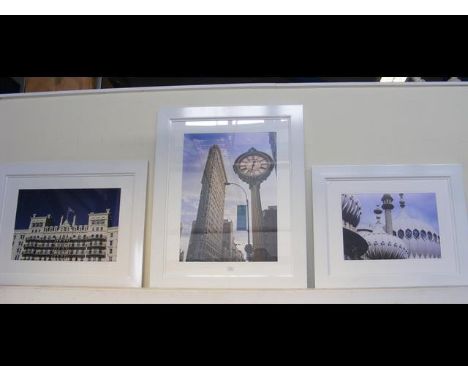 Three photographic prints of city scenes in white frames