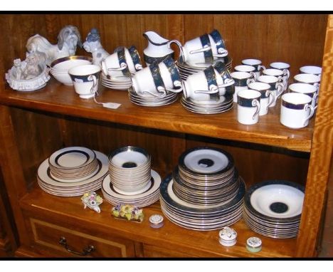 A medley of Royal Doulton 'Carlyle' and 'Harlow' English fine bone china, accompanied by Lladro dog figurines etc. - on two s