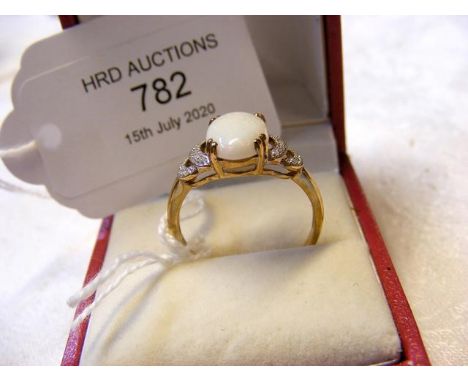 An opal and diamond ring in gold setting