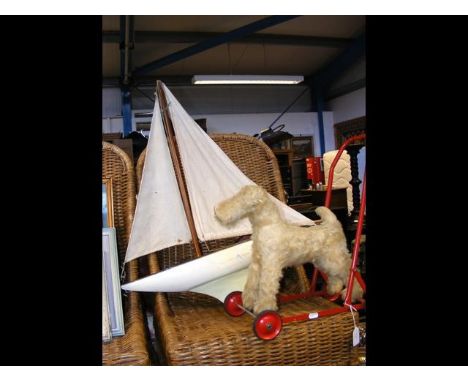 A vintage pond yacht together with vintage toy dog on trolley CONDITION REPORT62cm long19cm height61cm height of mast12cm wid