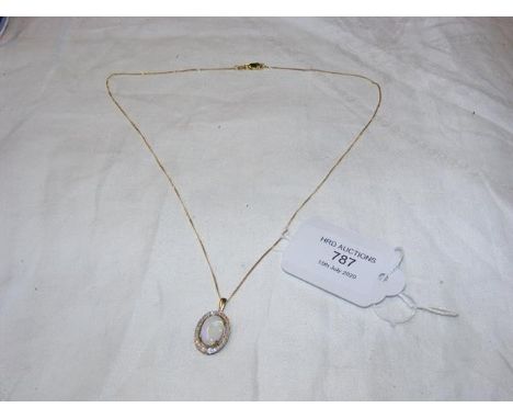 An opal and diamond pendant in gold setting with chain