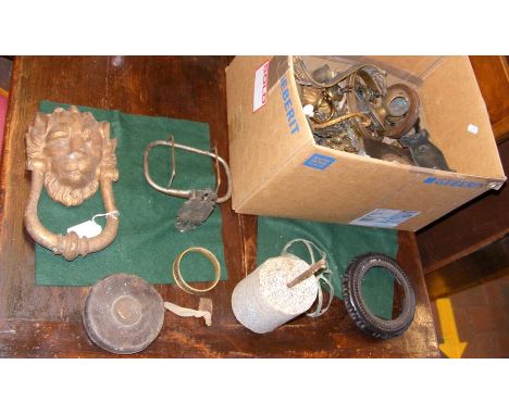 A sizeable lion door knocker in a box of assorted paraphernalia