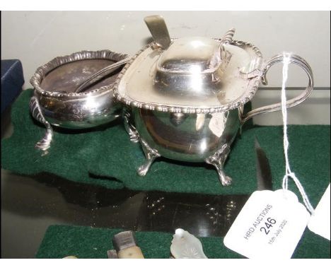 A large silver mustard pot with liner and spoon, together with a silver salt and spoon 