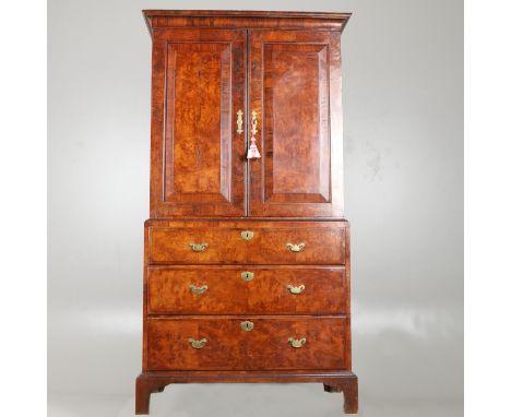 18th century and later, the top with feather-banded panelled doors enclosing a shelved interior on a three drawer base with b