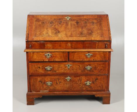 the fall front enclosing a pigeon hole interior, drawers and well, over two short and two long drawers raised on bracket feet