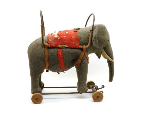 A Steiff elephant, upholstered in gray felt with applications, with a wrought iron harness on a wrought iron base, the base w