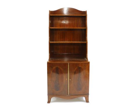 A Regency style strung mahogany waterfall bookcase, on a bow front cupboard base, raised on outswept bracket feet, oval inlai