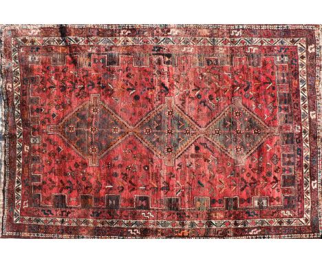 A Qashqai carpet, with three adjoined medallions enclosed by a castellated border, 316 x 228cmCondition report: Losses to tas