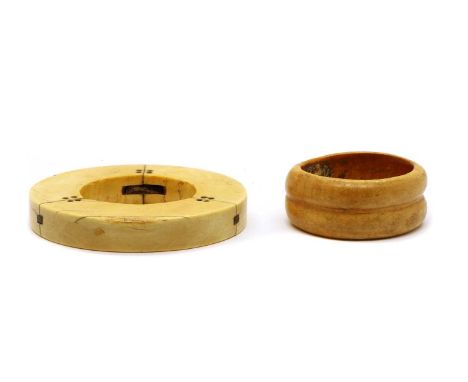 An ivory slave bangle, 18th/19th century, constructed of three pinned sections, 14cm diameter, together with another similar 