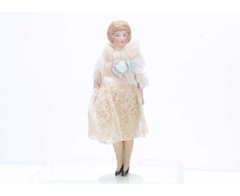An Edwardian bisque shoulder-head dolls' house lady doll, with light brown painted and moulded hair held in a bun, head turne