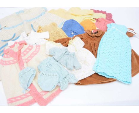 A quantity of knitted doll's clothing, mainly vintage, in a large plastic tub, with a corduroy coat and some Cinderella plast