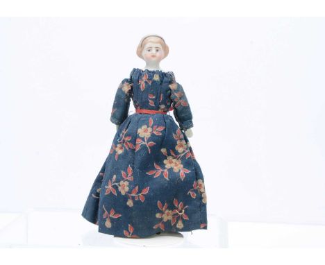 A 19th century bisque shoulder-head dolls' house doll, with blue painted eyes, light brown painted and moulded hair held by a