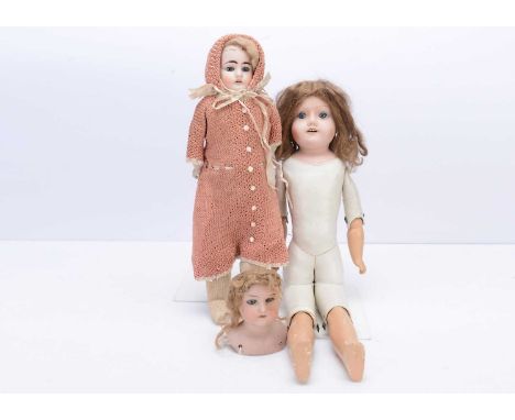 Three bisque shoulder-head dolls, an Ernst Heubach shoulder head with kid body and knitted outfit --18in. (46cm.) high; an AM