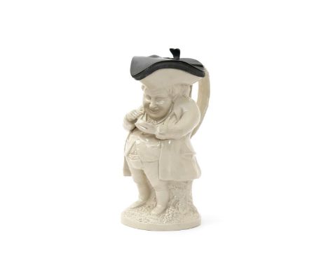 A salt-glazed stoneware Toby jug, 1st half 19th century, of the Snuff Taker, standing on a base moulded with grapevine, holdi