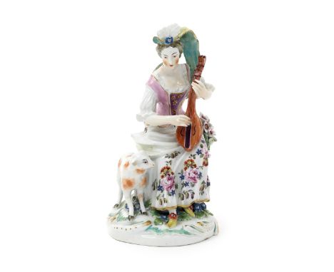 A Derby figure of a musical shepherdess, c.1760, seated on a low stump beside a flowering branch, playing the mandolin, a she