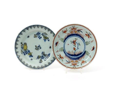 Two delftware plates, 18th century, one probably Bristol and painted in the Kakiemon palette with a flowering plant to the we