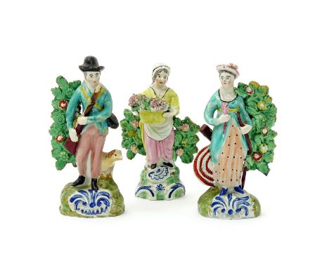 A pair of Staffordshire figures of a huntsman and a lady archer, c.1830-40, he carrying a gun and with his dog at his side, s