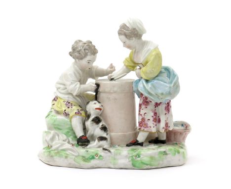 A rare Derby figure group of children playing Hazard, c.1780, a boy and a girl either side of a fortune wheel on top of a pil