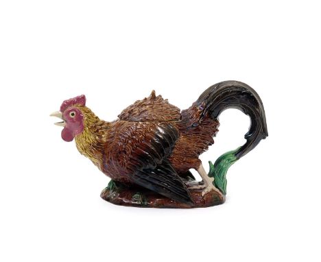 A George Jones Majolica novelty teapot and cover, c.1875, modelled as a cockerel in defensive pose, his beak agape and wings 