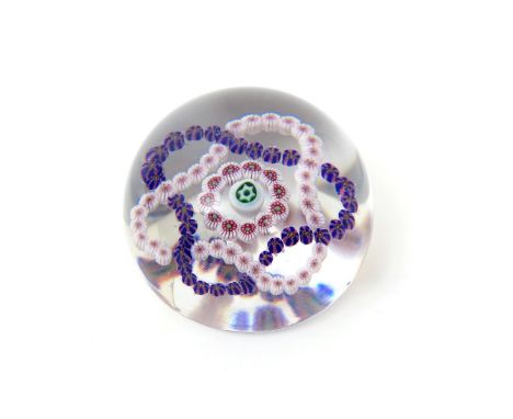 A French glass paperweight, c.1860, enclosing a garlanded design of two overlapping strings of canes, around a small ring and