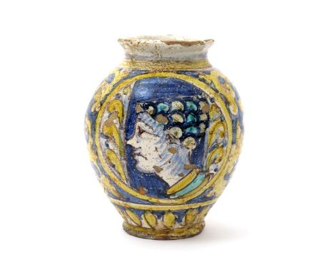 An Italian maiolica portrait bombola, 19th century or earlier, painted with a face in profile, wearing an elaborate scaled ha