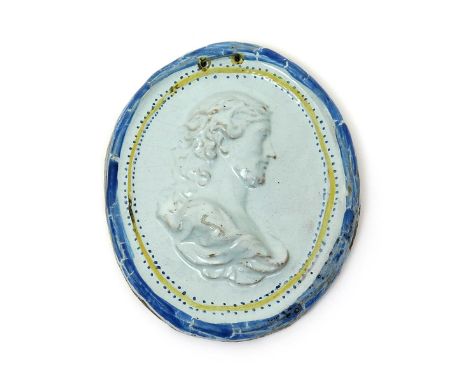 A Continental faïence portrait plaque, 18th century, moulded in high relief with a head and shoulders portrait in profile, pr